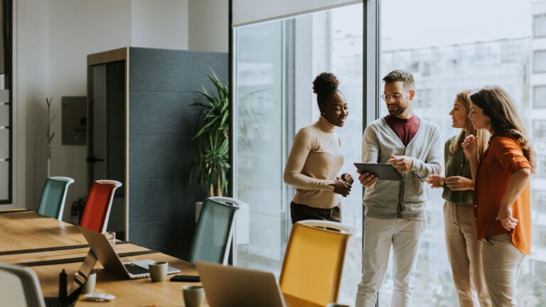 Photo of four people in an office meeting room